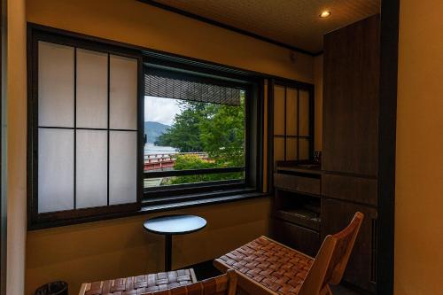 a room with a window and a table and a stool at Taikyourou in Miyazu