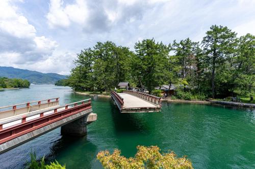 a bridge over a river with people walking on it at Taikyourou in Miyazu