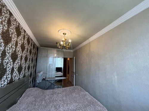 a bedroom with a bed and a chandelier at MarMar YVN in Yerevan