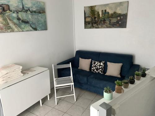 un salon avec un canapé bleu et une chaise dans l'établissement Cozy little duplex near Montmartre, à Paris