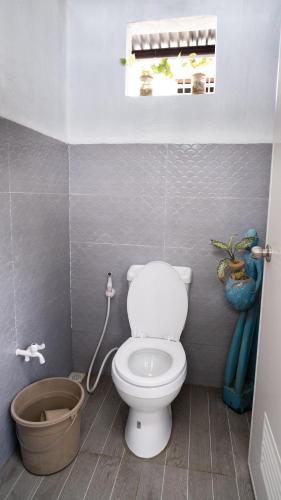 a bathroom with a toilet and a window and a bucket at Bucana Beach House North El Nido in El Nido