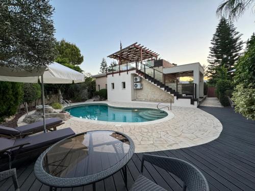 a backyard with a swimming pool and a house at Beautiful Villa in Latchi in the best location! in Neo Chorio