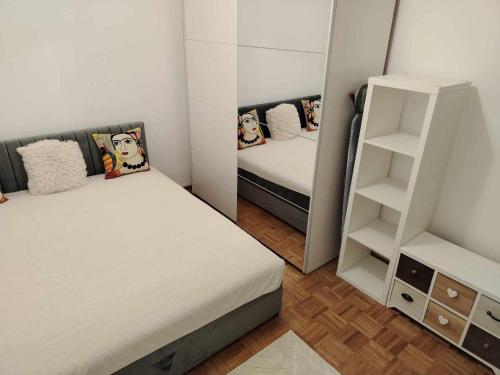a small room with two beds and a book shelf at Star Apartment Belgrade 1 in Belgrade