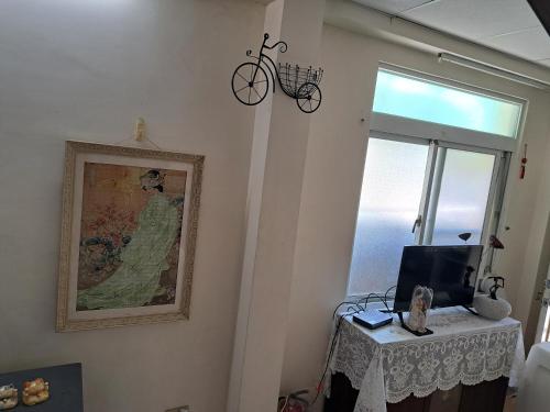 una habitación con una mesa y una foto y una bicicleta en la pared en Linsen Secret Realm 27, en Tainan