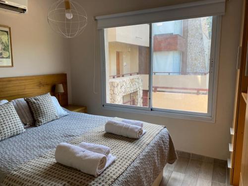 a bedroom with a bed with towels on it at Arena de Mar Depto F in Mar de las Pampas