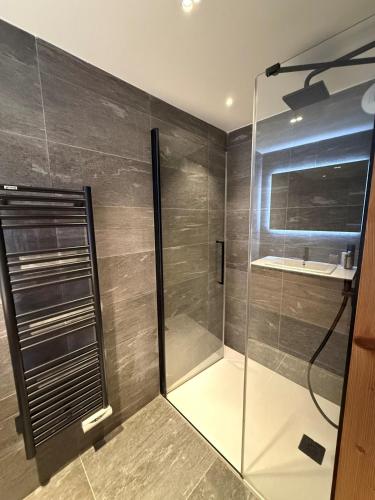 une douche avec une porte vitrée dans une salle de bain dans l'établissement Appartement neuf haut de gamme esprit chalet à Méribel - 4 couchages, à Méribel