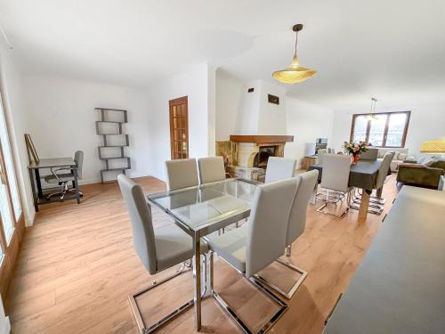 une salle à manger avec une table en verre et des chaises blanches dans l'établissement Grande maison familiale au calme avec jardin partagé, à Eaubonne