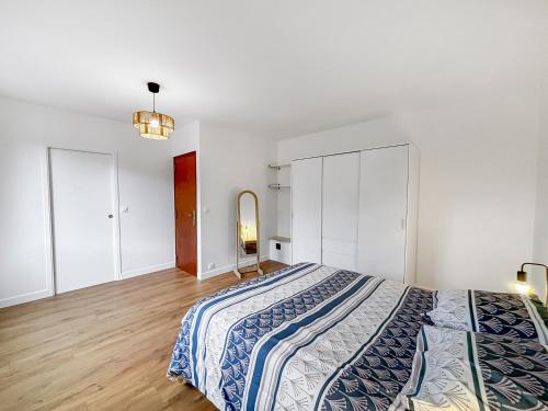 une chambre avec un grand lit et un miroir dans l'établissement Grande maison familiale au calme avec jardin partagé, à Eaubonne