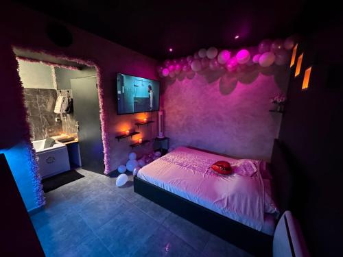 - une chambre violette avec un lit et un lavabo dans l'établissement love room spa jacuzzi, à Lyon