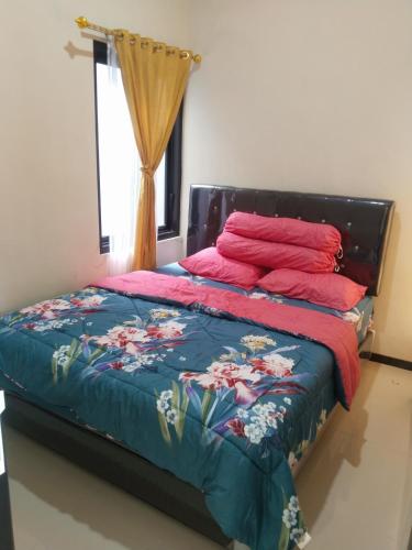 a bedroom with a bed with a blue comforter at Vila Alief Batu in Tlekung
