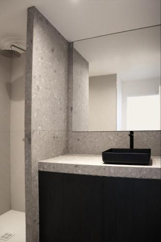 une salle de bain avec un lavabo et un miroir dans l'établissement Kavell, à Pléneuf-Val-André