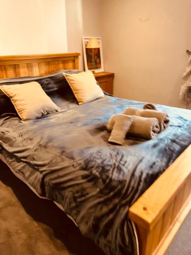 a large bed in a bedroom with a wooden frame at Spacious 5 Bedroom Home in Central Kidderminster with Private Parking and Electric Vehicle Facilities, Easy Access to Birmingham and Nearby Towns in Kidderminster
