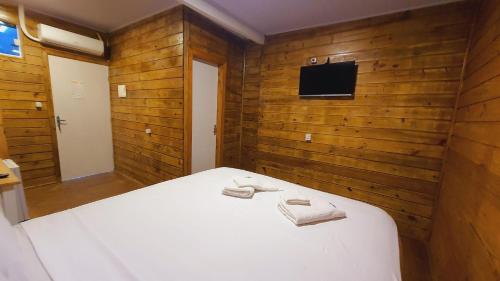 a bedroom with a white bed with wooden walls at iG Pousada - Frente Mar in Florianópolis
