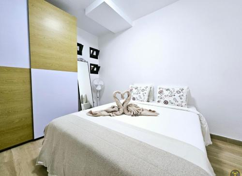 a bedroom with a large white bed with a brown ribbon at Casa Los Volcanes a primera línea del mar in Teguise