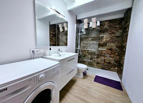a white bathroom with a washer and dryer in it at Casa Los Volcanes a primera línea del mar in Teguise