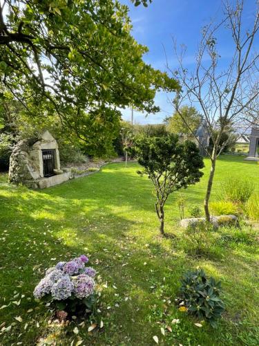 a garden with flowers in a grassy yard at Ty Marie Neiz Vran - Villa luxe vue mer, 80 mètres de la plage in Kerlouan