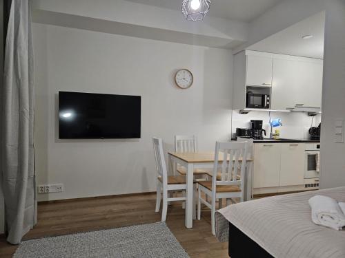 a room with a table and chairs and a kitchen at Studio Apartment Aurora in Rovaniemi