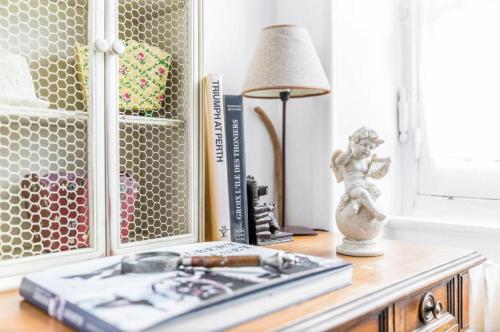 una mesa con una lámpara y libros sobre una mesa con una lámpara en Appartement de charme coeur historique parking privé, en Vannes