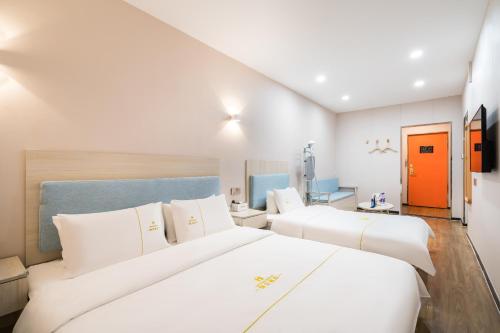 a hotel room with two beds and an orange door at Dequan Hotel Guangqumen Outer Branch in Beijing