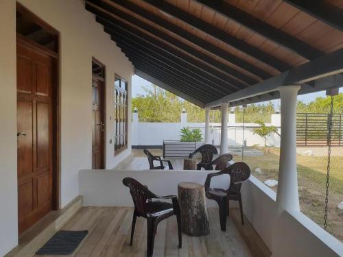 a porch with chairs and a table on a porch at Blu Marine Nilaveli in Trincomalee