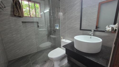 a bathroom with a sink and a toilet and a mirror at Valentina Resort & Spa Phu Quoc in Phu Quoc