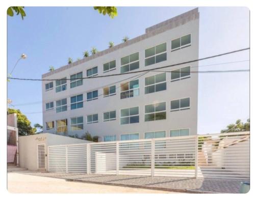 ポルト・デ・ガリーニャスにあるPorto Sunset Flat Aline Duqueの前に柵がある白い建物