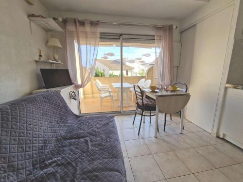 - une chambre avec un lit, une table et un balcon dans l'établissement Agréable Appart 4 Pers. Proche Plage avec Terrasse et Parking Privé - FR-1-387-45, à Marseillan