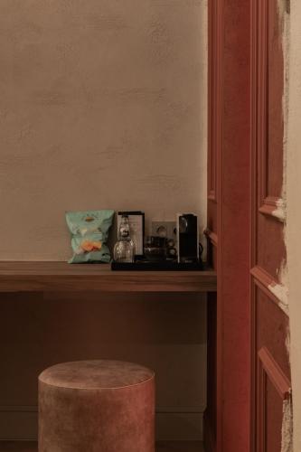a shelf with some items on it with a stool at B&B Herenhuis in Izegem
