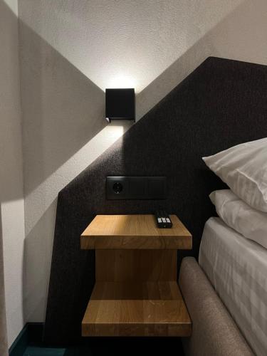 a bed room with a night stand next to a bed at Котеджі Грань in Bukovel