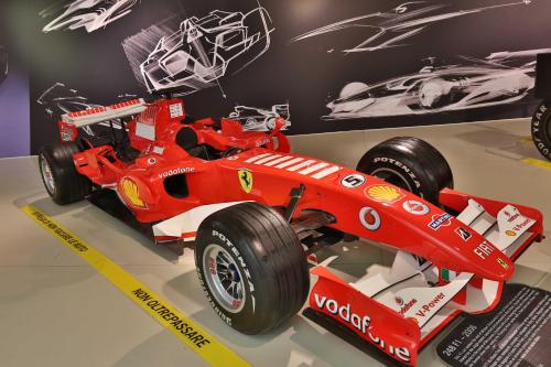 a red race car on display in a museum at Central Park Hotel Modena in Modena