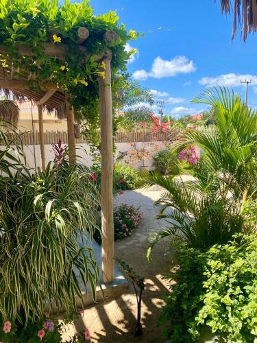a garden with a pergola with flowers and plants at Nordisch- Chalés in Prea