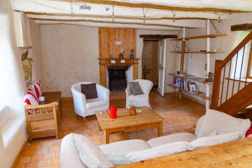 Elle comprend un salon doté d'un mobilier blanc et d'une cheminée. dans l'établissement La Maison, à Crozon