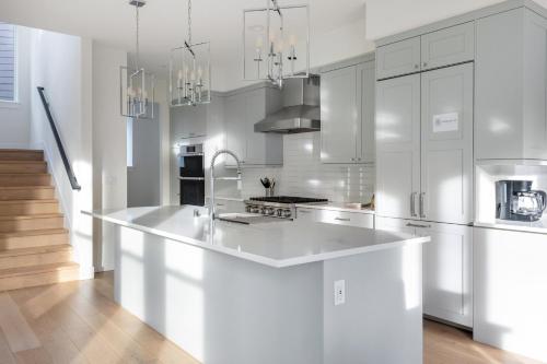 a kitchen with white cabinets and a large white island at Elegant 3-Story House with Private Backyard in WA in Kirkland