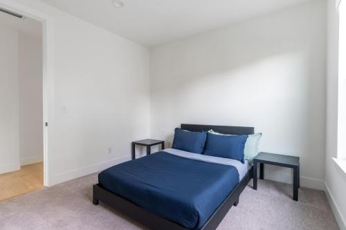 a bedroom with a bed with blue sheets and blue pillows at Elegant 3-Story House with Private Backyard in WA in Kirkland