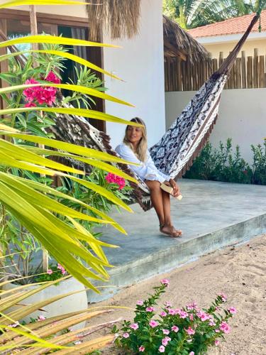 a woman sitting on a hammock on a house at Nordisch- Chalés in Prea