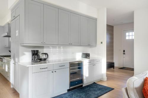 a white kitchen with white cabinets and a blue rug at Elegant 3-Story House with Private Backyard in WA in Kirkland