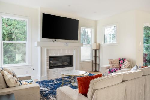 a living room with a fireplace and a flat screen tv at Elegant 3-Story House with Private Backyard in WA in Kirkland