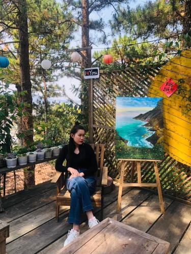 a woman sitting on a chair next to a painting at Balabum home and more in Trai Mat