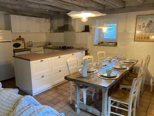 une cuisine avec une table avec des chaises et une salle à manger dans l'établissement la maison de Pascaline, à Campan