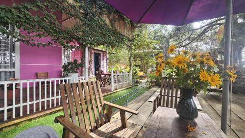 a porch with two benches and a vase of flowers at Balabum home and more in Trai Mat