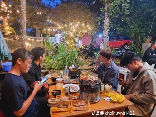 a group of men sitting around a table with food at Balabum home and more in Trai Mat