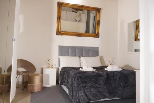 a bedroom with a bed with a mirror on the wall at THE GRAND VIEW Lux Vatican Suite in Rome