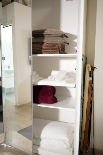 a glass closet with white shelves and towels at THE GRAND VIEW Lux Vatican Suite in Rome