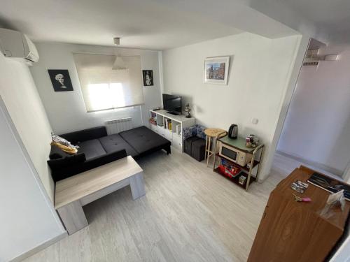 a living room with a black couch and a table at Piso con Vistas y Mucho Encanto in Madrid