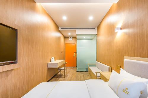 a hotel room with a bed and a tv at Dequan Hotel Guangqumen Outer Branch in Beijing