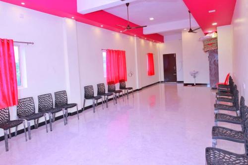 an empty room with chairs and red curtains at Hotel SONIA MAHI INN KANYAKUMARI in Kanyakumari