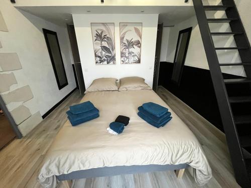 Ce lit se trouve dans un dortoir doté d'oreillers bleus. dans l'établissement La Baudiniere - Maison avec jardin, à Artannes-sur-Indre