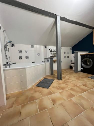La salle de bains mansardée est pourvue d'une baignoire et d'un lavabo. dans l'établissement La Baudiniere - Maison avec jardin, à Artannes-sur-Indre