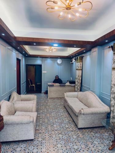 a man sitting at a desk in a room with couches at Darjeeling Homes The Grace in Darjeeling