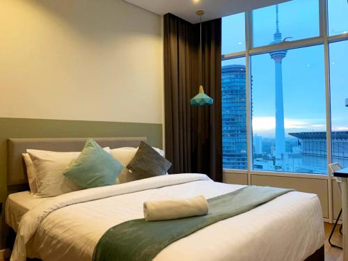 a bedroom with a large bed with a large window at Apartment Sky by MonoSuites KLCC in Kuala Lumpur